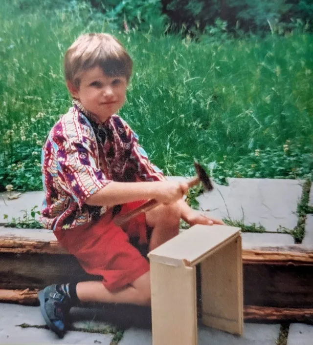 Hendrik as a child building with wood and a hammer